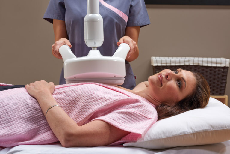 Technician using ABUS to scan a woman's chest, while she is laying down in an room