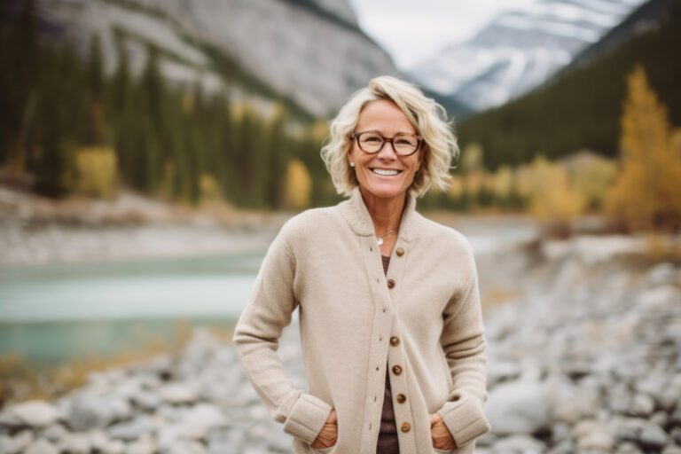 Grinning woman in her 50s while on a hike in the mountains